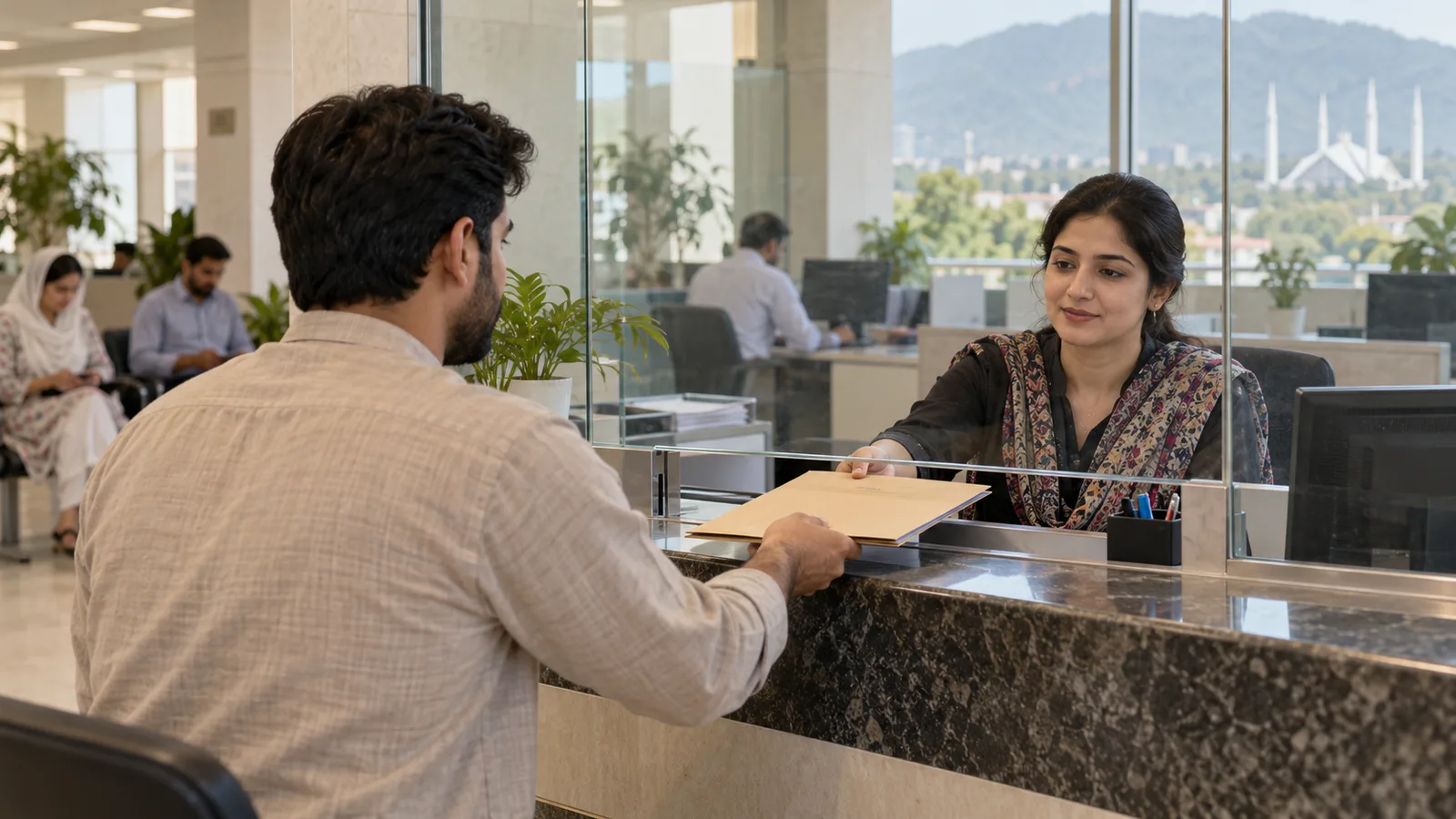 A Pakistani applicant hands a document folder to a clerk behind glass at a government office counter in Islamabad.